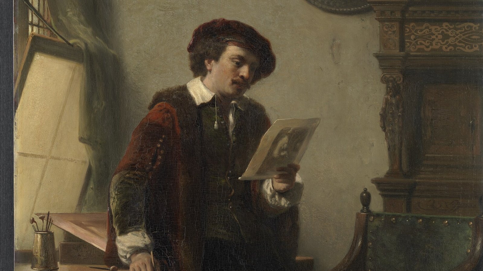 The young Rembrandt in his studio, examining a print in his hand by the light of a window
