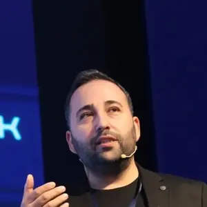 Kaan Gülten sahnede kulaklık mikrofonla konuşurken, yakın plan