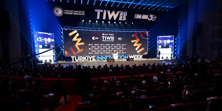 Türkiye İnovasyon Haftası ana sahnesi: dev ekranlarda TIW logosu ve salonu dolduran izleyiciler