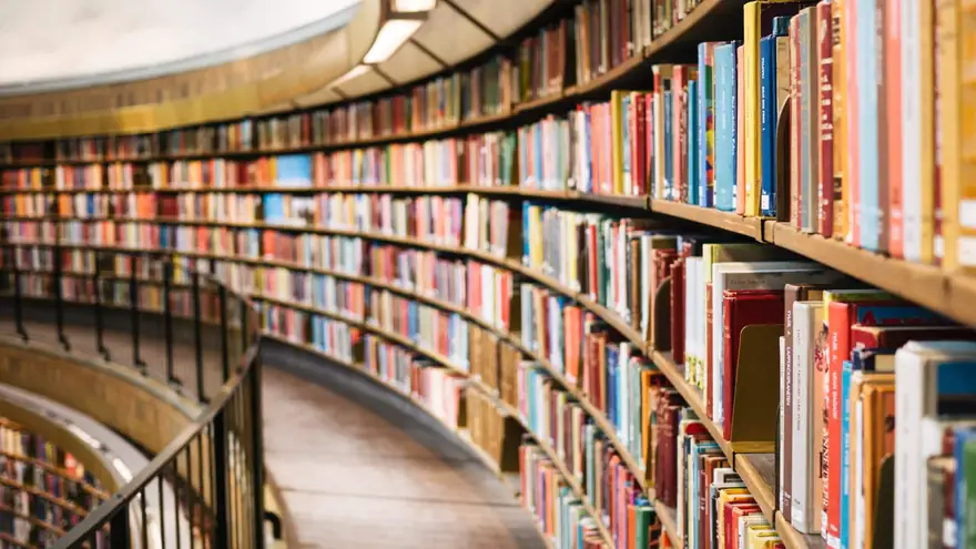Kavisli rafları kitaplarla dolu, yuvarlak bir kütüphane koridoru